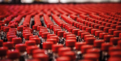 Soft drinks bottled lined up in rows with red lids