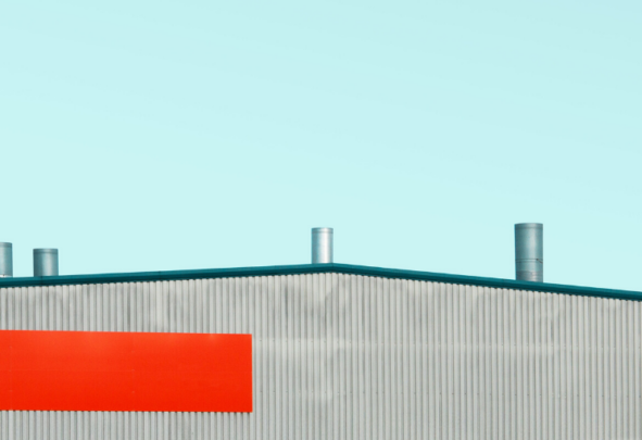 The roof of a metal warehouse against a blue sky
