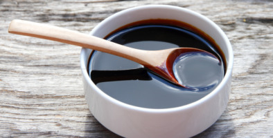 A bowl full of molasses with a spoon