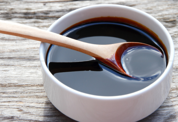 A bowl full of molasses with a spoon