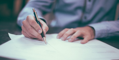 Hands signing a document