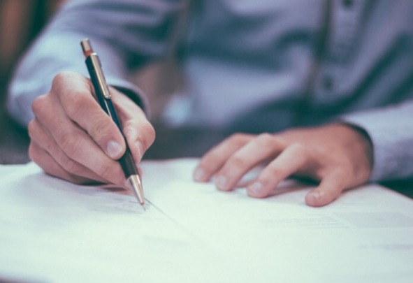 Hands signing a document