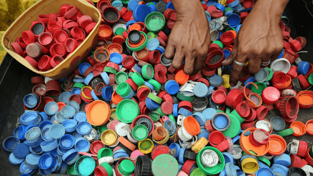 hands sorting coloured bottle caps