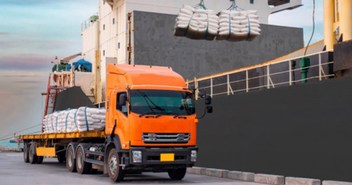 white sugar being moved from a ship to a truck