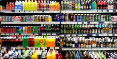 a shelf showing soft beverages and some alcoholic beverages