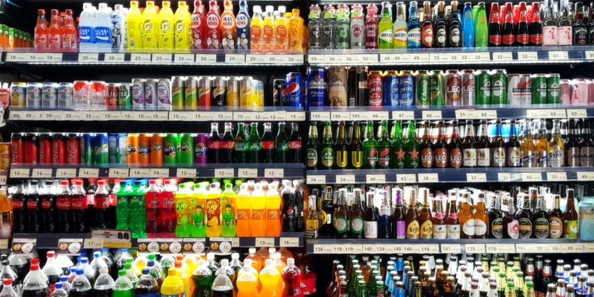a shelf showing soft beverages and some alcoholic beverages
