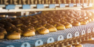 Three tiered conveyor belt of fresh, golden cakes